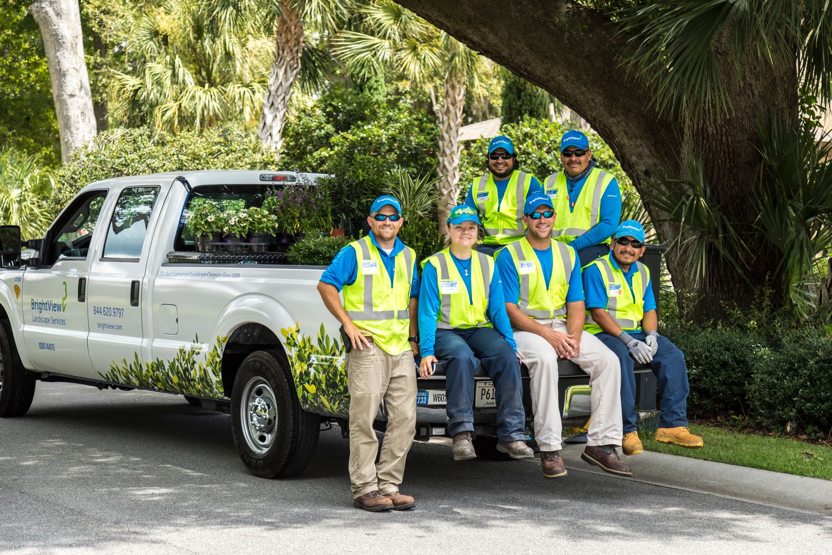 landscape maintenance crew sitting on truck tailgate